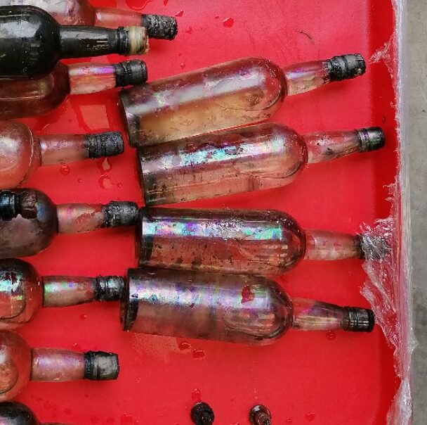 SS Mantola gin bottles recovered from 2500 metres, showing iridescence from century at depth